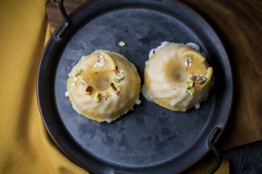 Sarı ve siyah arkaplanlı şekerli limonlu pasta. Turtalı kek, haşhaşlı, geleneksel Amerikan mutfağı koyu tonda.
