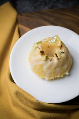 Tatlı olarak beyaz tabakta servis edilen limonlu kek. Bu pasta limon suyu, tereyağı ve diğer malzemelerden yapılır. Pastanın tadı tatlı ve ekşi..