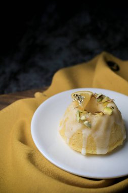 Tatlı olarak beyaz tabakta servis edilen limonlu kek. Bu pasta limon suyu, tereyağı ve diğer malzemelerden yapılır. Pastanın tadı tatlı ve ekşi..