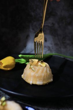 Koyu arkaplanda sarı lale yakınında güneş ışığı altında şekerli limonlu pasta. Turtayla geleneksel Amerikan mutfağı..