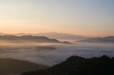 Güneş doğarken dağ manzarasında inanılmaz bir sis denizi. Taze ve gevşemiş doğa tipi