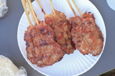 Möö ping, Tayland usulü ızgara bbq domuz şişleri ve beyaz tabakta yapışkan pirinç. Asya sokak yemekleri.