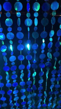 Soyut parlak mavi pullu perde hareket ediyor ve parıldayan ışığı yansıtıyor büyüleyici bir doku etkisi yaratıyor.