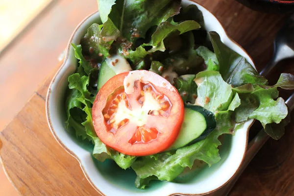 Beyaz kasede taze salata, salata ve domates. Sağlıklı diyet yemekleri, vejetaryen ürünleri.
