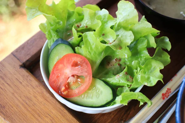 Beyaz kasede taze salata, salata ve domates. Sağlıklı diyet yemekleri, vejetaryen ürünleri.