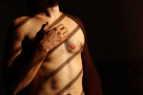 young man with red heart on chest