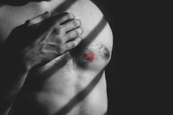 man with red heart on chest