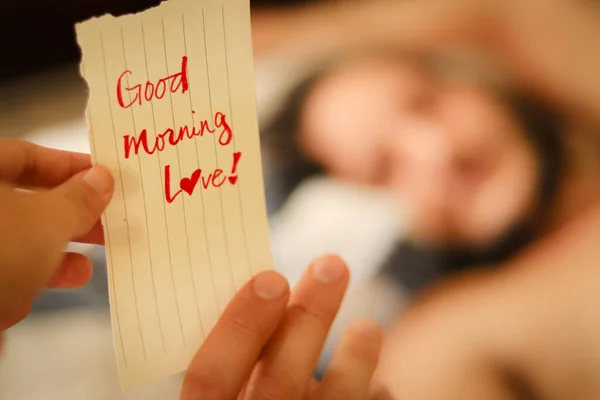 Bir çarşaf kağıt ve kalem tutan bir kadın..