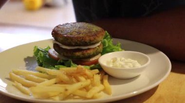 Patates kızartması ve vegan mayonezli falafel burger yemek. Hem sağlıklı hem de zalimce olmayan saf bitki temelli bir yemek.