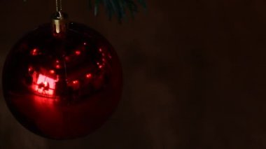 Parıldayan ışıkların kavramsal videosu kırmızı bir Noel balosu süslemesine yansıyor.