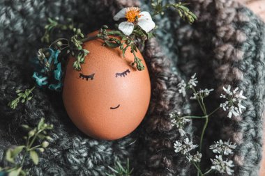 Paskalya ve Bahar sezonunun gelişi için bir süs ve sembol olarak çiçek taçlı yumurtayı kapat.