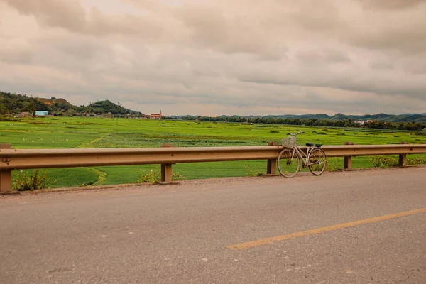 Old fashioned bicycle park at the side of a countryside road on a bright sunny summer day