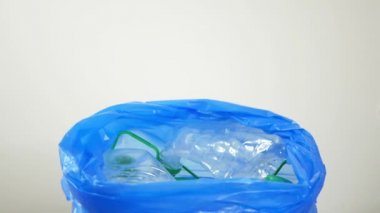El kullanılmış plastik şişeleri mavi pakete koyar. Kullanılmış plastik şişeler. Modern insanlık sorunu kavramı. Küresel kirlilik ve modern kirliliği çözmenin yolu.
