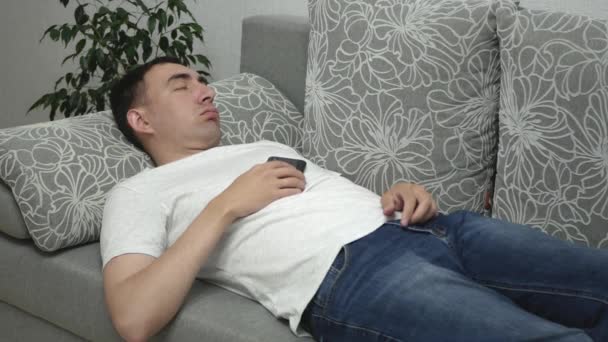 Muž Spí Šedém Gauči Muž Drží Smartphone Břiše Spí Vyčerpaný — Stock video