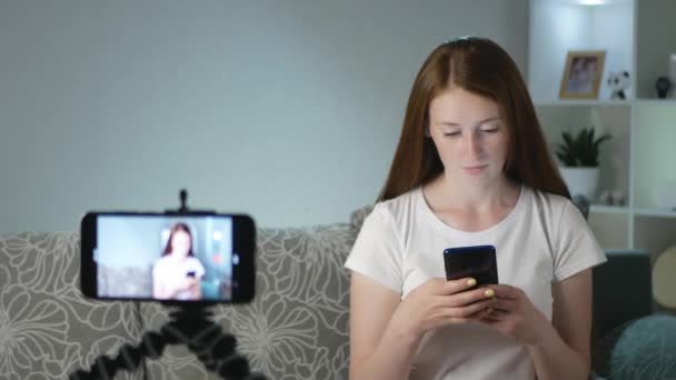 スマートフォンで何かに驚かされ 笑う女性ブロガー ブロガーは彼女のチャンネルのビデオを作る Vloggerはソーシャルメディア用のビデオを記録します 加入者のための女性のVloggerストリーム — ストック動画