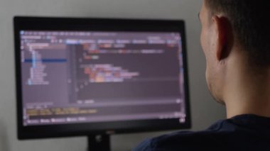 Hacker bir programı, bir uygulamayı ya da veri tabanını hackliyor. Hacker saldırısı kavramı. Programcı kod yazıyor ya da bir uygulama yazıyor. Serbest programcı evde çalışıyor.