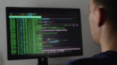 Hacker bir programı, bir uygulamayı ya da veri tabanını hackliyor. Hacker saldırısı kavramı. Programcı kod yazıyor ya da bir uygulama yazıyor. Serbest programcı evde çalışıyor.