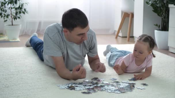 Dochter Vader Kiezen Een Puzzel Liggen Thuis Vloer Schattig Klein — Stockvideo