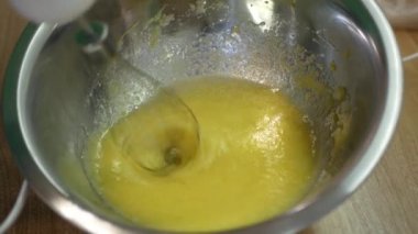 Yumurta ve şekerin karışımına yakından bak. Kadın metal kasede yumurta ve şekeri harmanlıyor. Mutfakta tatlı pişirme manzarasını kapat..