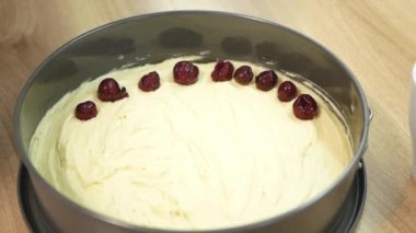 Pasta tabağında kirazları turta hamuruna yatırma görüntüsünü kapat. Kadın turta hamurunun üzerine kiraz serer. Mutfakta tatlı pişirme manzarasını kapat..