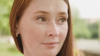 Kızıl saçlı güzel bir kadının yakın görüntüsü. Kızıl saçlı çekici bir kadına yakından bak. Yüzünde çiller olan yetişkin birinin portresi. Doğal güzellik.. 