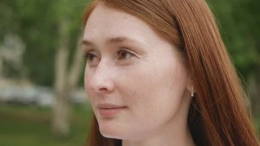 Kızıl saçlı güzel bir kadının yakın görüntüsü. Kızıl saçlı çekici bir kadına yakından bak. Yüzünde çiller olan yetişkin birinin portresi. Doğal güzellik.. 