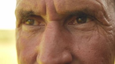 Bıyıklı olgun bir adama yakından bak. Yüzünde kırışıklıklar olan yaşlı adama yakından bak. Yetişkin birinin portresi.