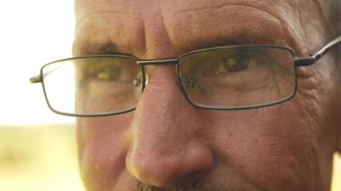 Bıyıklı olgun bir adama yakından bak. Yüzünde kırışıklıklar olan yaşlı adama yakından bak. Yetişkin birinin portresi.