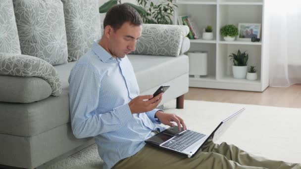 Volwassen Man Kijkt Naar Smartphone Typen Laptop Freelancer Werkt Thuis — Stockvideo