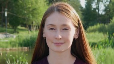 Kızıl saçlı güzel bir kadının yakın görüntüsü. Kızıl saçlı çekici bir kadına yakından bak. Yüzünde çiller olan yetişkin birinin portresi. Doğal güzellik..