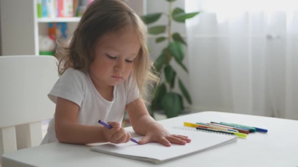 かわいい幼児の女の子はフェルトチップペンで描きます 家で幼児の女の子の肖像 — ストック動画
