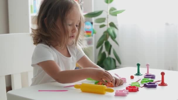 可爱的蹒跚学步的小女孩玩塑料玩具 家里蹒跚学步女孩的画像 — 图库视频影像