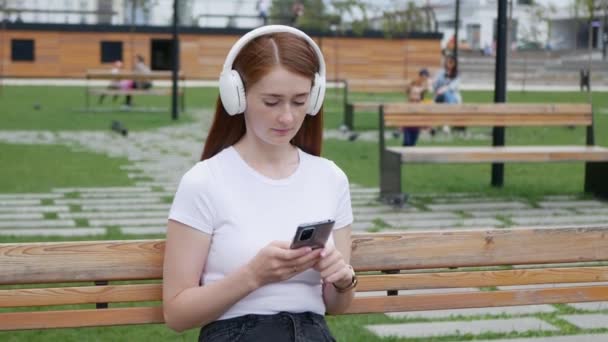 Kızıl Saçlı Güzel Bir Kadın Müzik Dinler Akıllı Telefon Kullanır — Stok video