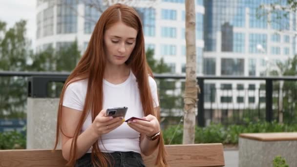 Kızıl Saçlı Güzel Bir Kadın Akıllı Telefondan Kredi Kartı Bilgilerini — Stok video