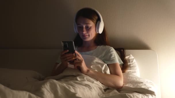 Aantrekkelijke Vrouw Met Rood Haar Gebruikt Smartphone Luistert Naar Muziek — Stockvideo