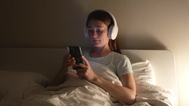 Aantrekkelijke Vrouw Met Rood Haar Gebruikt Smartphone Luistert Naar Muziek — Stockvideo