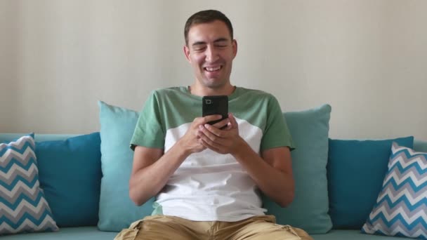 Красивый Молодой Человек Смотрит Смешные Видео Изображения Смартфоне Смеется Привлекательный — стоковое видео