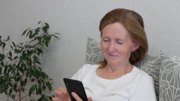 Middelbare Vrouw Kijkt Iets Smartphone Glimlacht Gelukkig Rood Haar Vrouw — Stockvideo