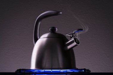 Bir soba üzerinde dumanı tüten çaydanlık