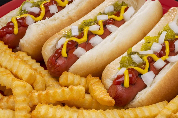 Tres deliciosos hot dogs con papas fritas — Foto de Stock