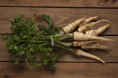 Maydanoz kökü ile bir rustik koyu arka plan üzerinde yukarıdan çekim yaprakları