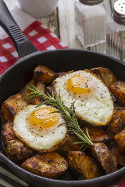 Ovos fritos e batatas em uma mesa de café da manhã — Fotografia de Stock