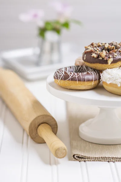 Donuts frescos en un pedestal blanco en un entorno de cocina casera Imágenes de stock libres de derechos