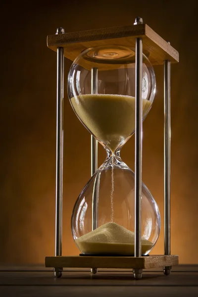 Hourglass on a rustic background Stock Picture