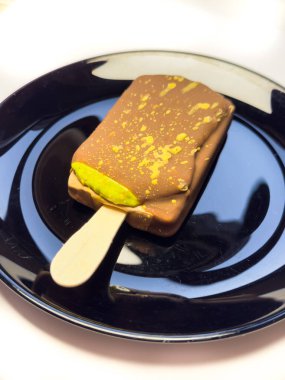 Dubai çikolatalı dondurma, çubukta dondurma. Siyah tabakta dondurma, fotokopi alanı, üst manzara, düz yer. Yüksek kalite