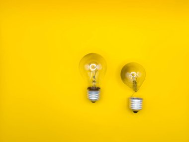 Tungsten ampul lambası. Çalışmayan ampul, kırık ampul. Işık ve karanlık kavramı, fikir, elektrik kopyalama alanı, deri döşeme, üst manzara sarı zemin. Yüksek kalite
