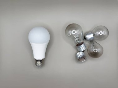 Modern LED lamba, elektrik tasarrufu. Tungsten ampul lambası. Çalışmayan ampul, kırık ampul. Aydınlık ve karanlık kavramı, fikir, elektrik gri arka plan. Yüksek kalite