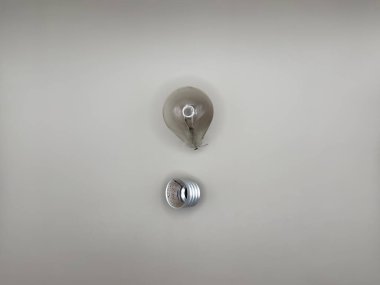 Tungsten ampul lambası. Çalışmayan ampul, kırık ampul. Aydınlık ve karanlık kavramı, fikir, elektrik kopyalama alanı, deri yüzme, üst görüş. gri arkaplan Yüksek kalite