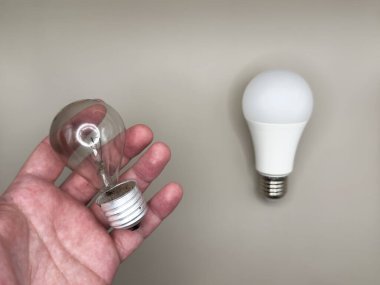 Modern LED lamba, elektrik tasarrufu. Tungsten ampul lambası. Çalışmayan ampul, kırık ampul. Aydınlık ve karanlık kavramı, fikir, elektrik gri arka plan. Yüksek kalite