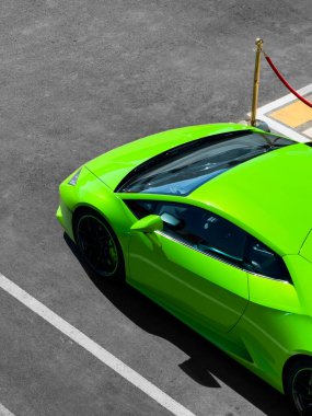 Bir alışveriş merkezinin otoparkındaki parlak yeşil spor araba, afiş için, reklam için, üst manzara için. Yüksek kalite